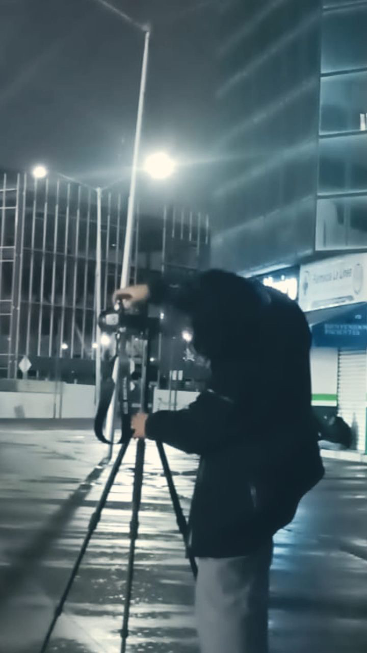 Silueta de Luis fotografiando de noche en la calle con la camara en mano